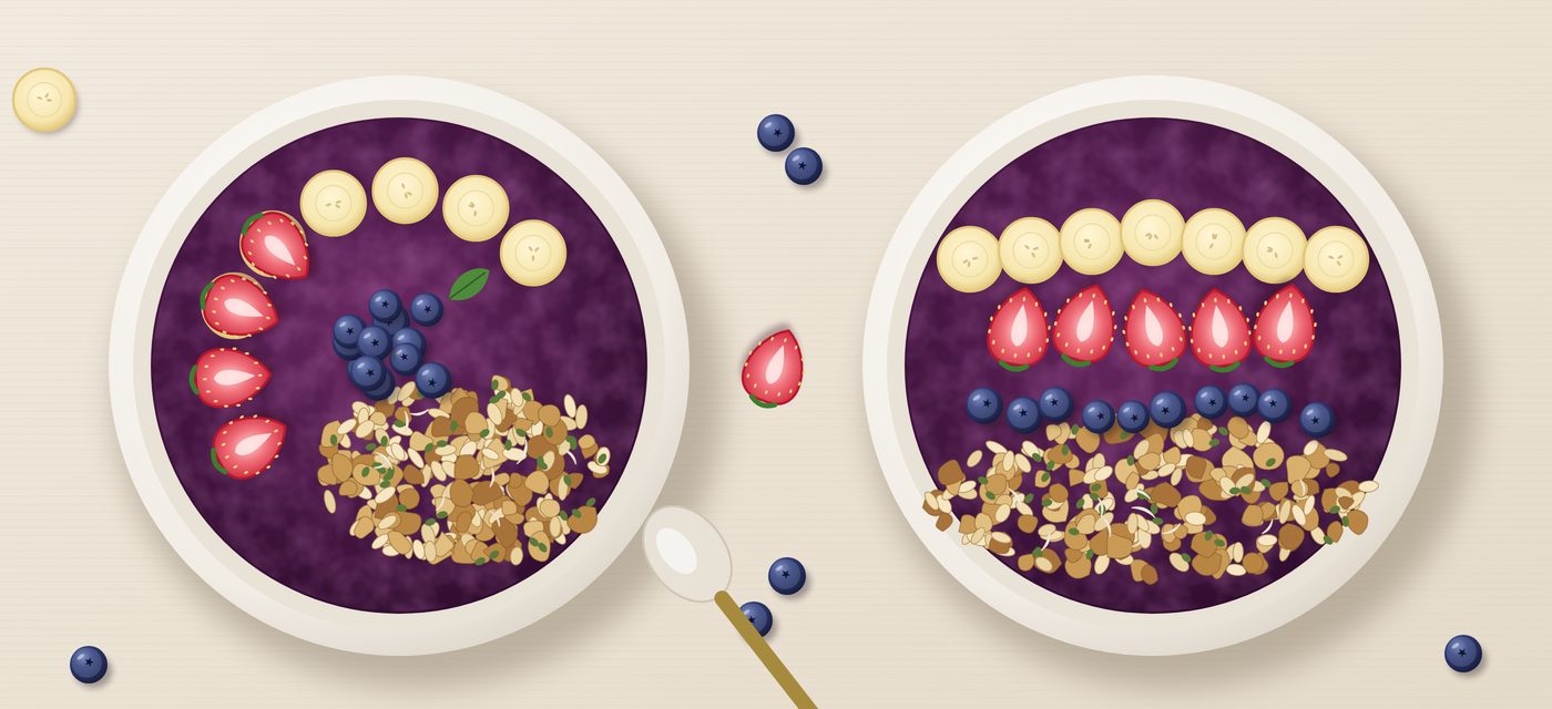 Two açaí bowls topped with strawberries, banana, blueberries and granola