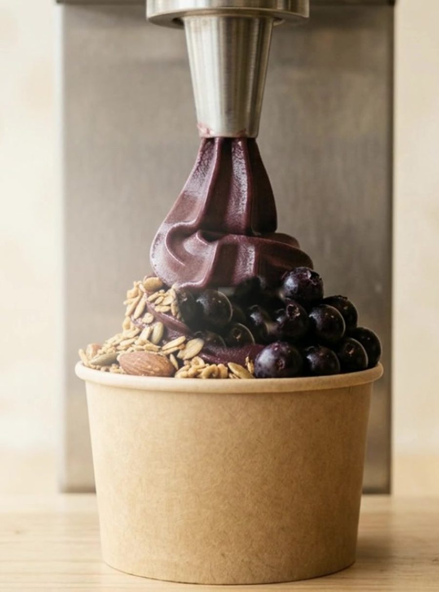Açaí soft serve in a kraft cup topped with granola and blueberries